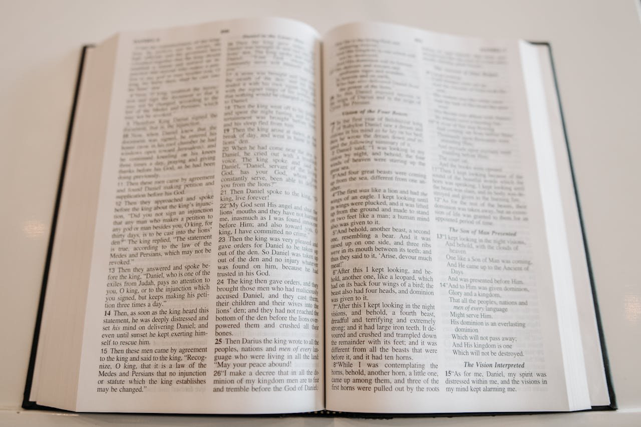 An open Holy Bible on a wooden table, showcasing scripture text, ideal for religious and spiritual themes.